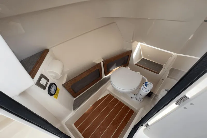 Slide: The Image of 2024 Grady-White Freedom 235 boat interior with toilet and wooden flooring. - 16