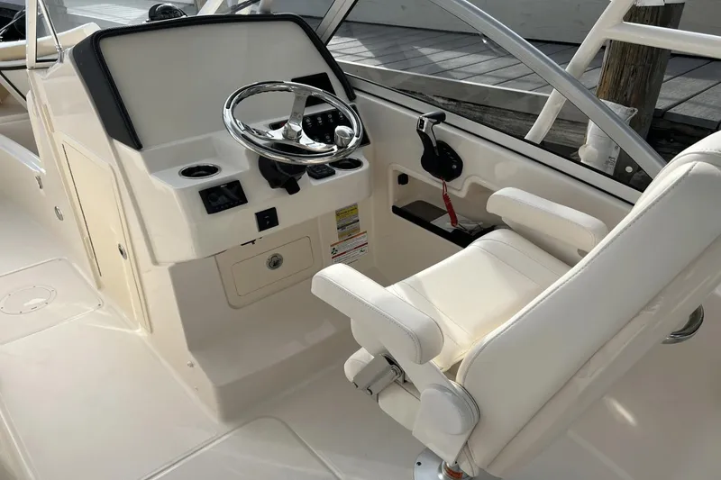 Slide: The Image of 2024 Grady-White Freedom 235 boat helm with steering wheel and captain's chair. - 17