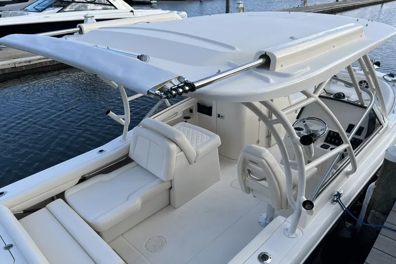 Slide: The Image of 2024 Grady-White Freedom 235 boat interior at dock, featuring seating and helm. - 3