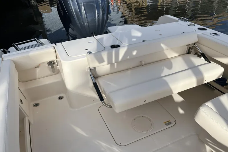 Slide: The Image of 2024 Grady-White Freedom 235 boat interior with white seating and motor. - 5