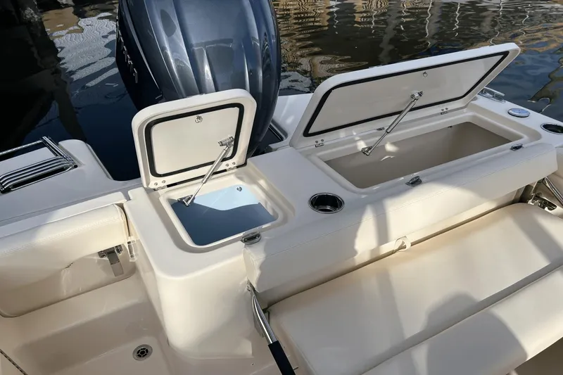 Slide: The Image of 2024 Grady-White Freedom 235 boat with open storage compartments and engine. - 6
