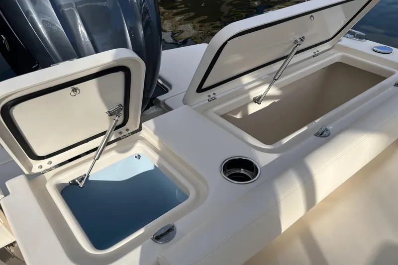 Slide: The Image of 2024 Grady-White Freedom 235 boat storage compartments and cup holder. - 7