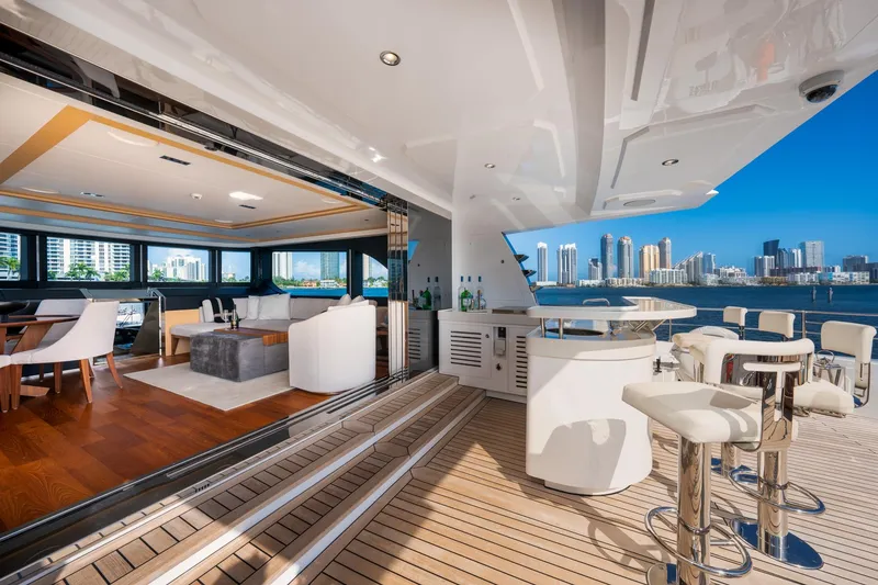 Slide: The Image of Luxurious 2020 Majesty 100 yacht interior with open deck, bar, and city skyline view. - 14
