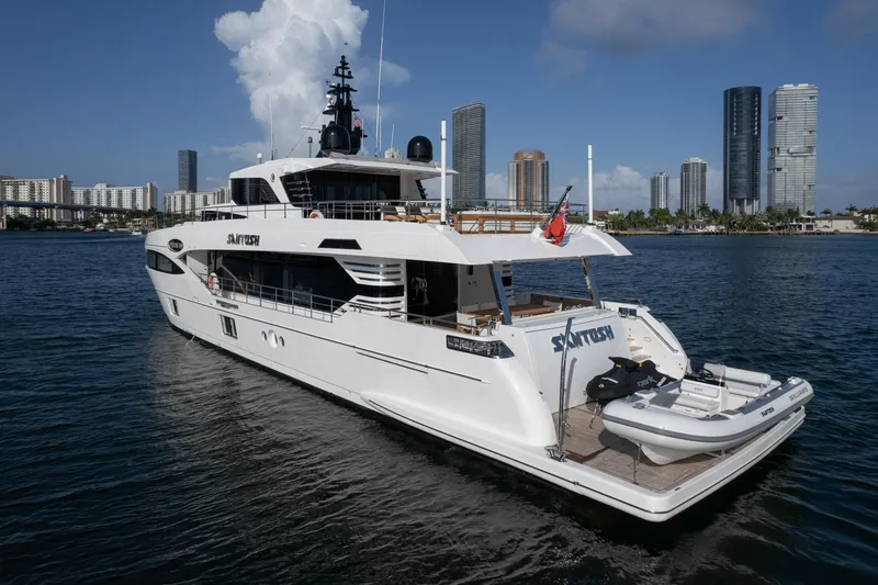 Slide: The Image of Luxury 2020 Majesty 100 yacht docked in a city marina with skyscrapers in the background. - 21