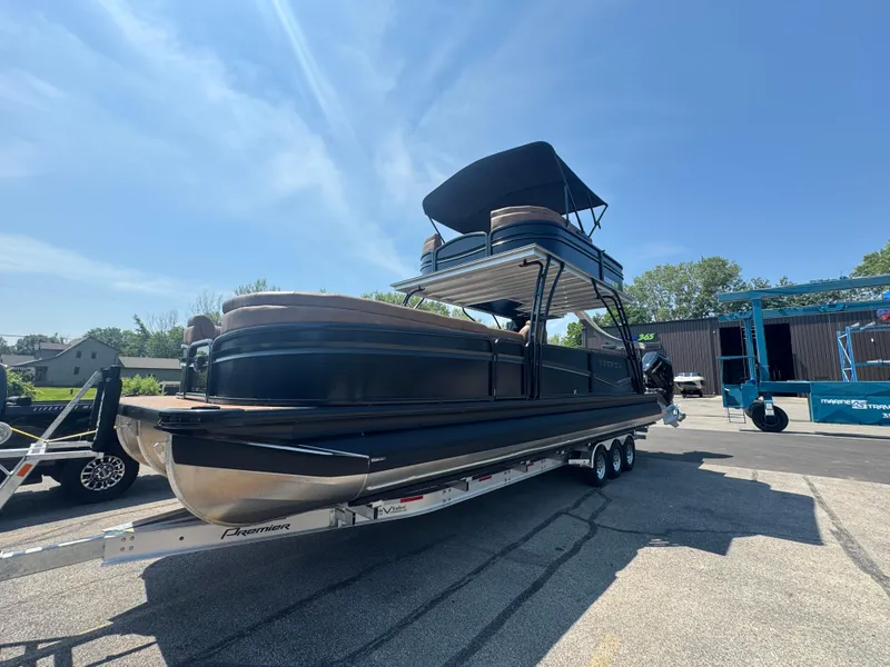 Slide: The Image of 2026 Premier Escalante pontoon boat on trailer under clear blue sky. - 5