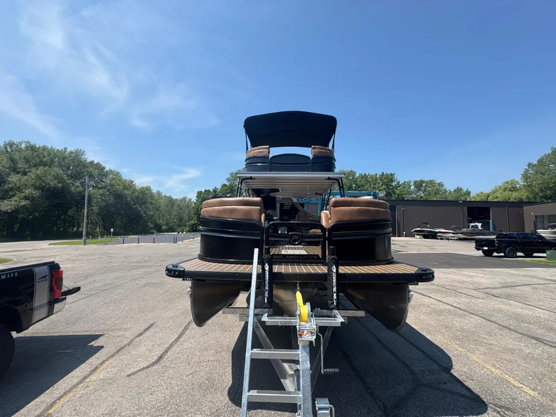 Slide: The Image of 2026 Premier Escalante pontoon boat on trailer in parking lot under clear blue sky. - 6