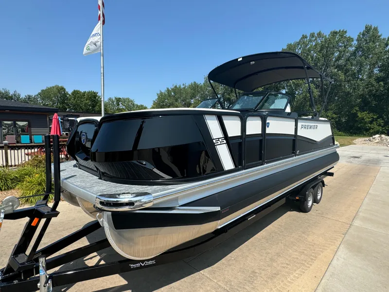 Slide: The Image of 2024 Premier Supersport boat on trailer, sleek black and white design, outdoor setting. - 2