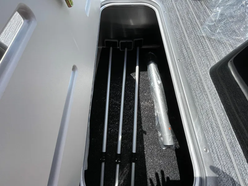 Slide: The Image of Storage compartment in 2024 Premier Supersport boat with organized rods and equipment. - 24