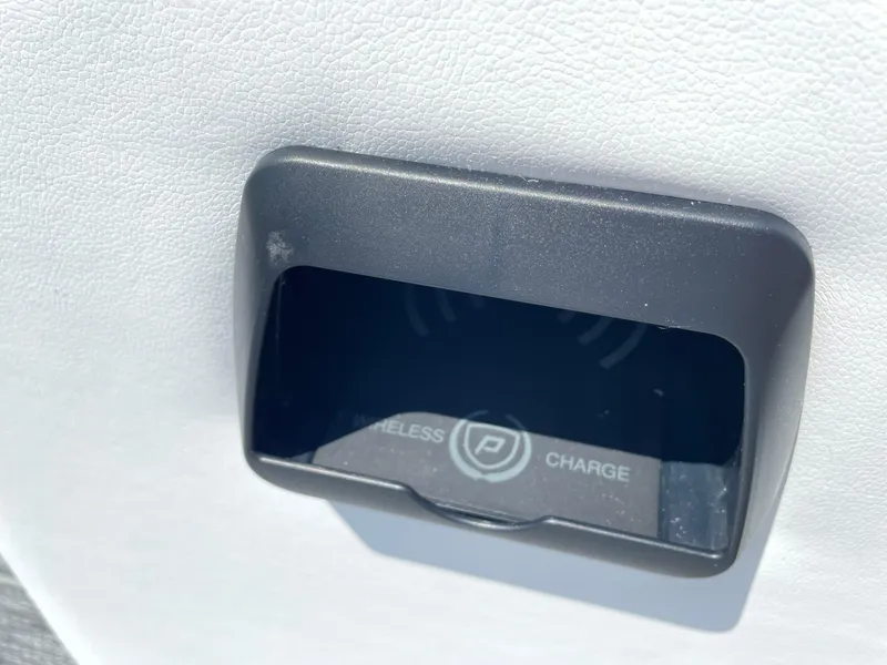 Slide: The Image of 2024 Premier Supersport wireless charging compartment on white interior. - 25