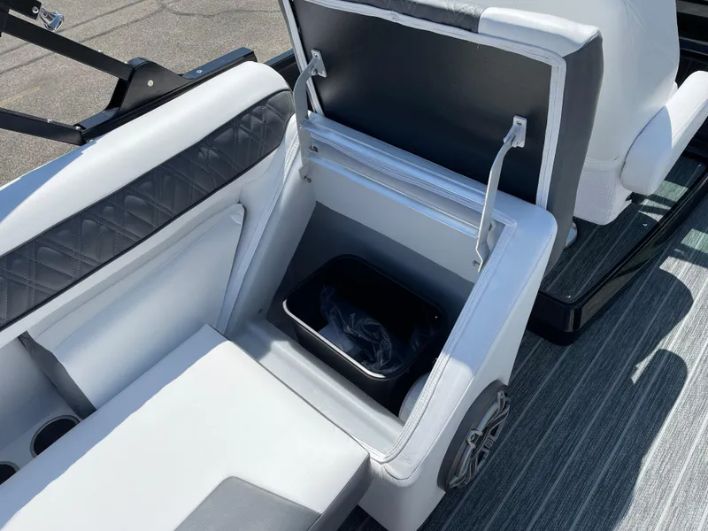 Slide: The Image of 2024 Premier Supersport boat seat with open storage compartment and trash bin. - 33