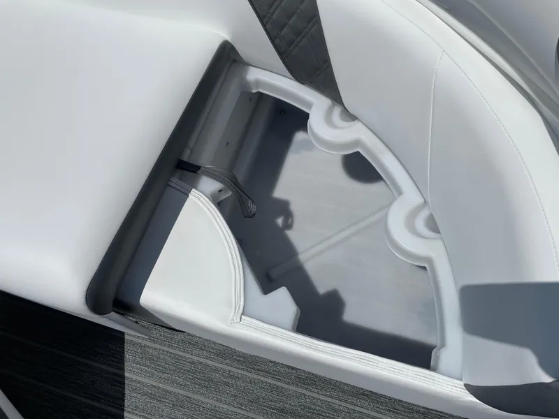 Slide: The Image of 2024 Premier Supersport boat seat storage compartment with cup holders, featuring sleek white upholstery. - 34