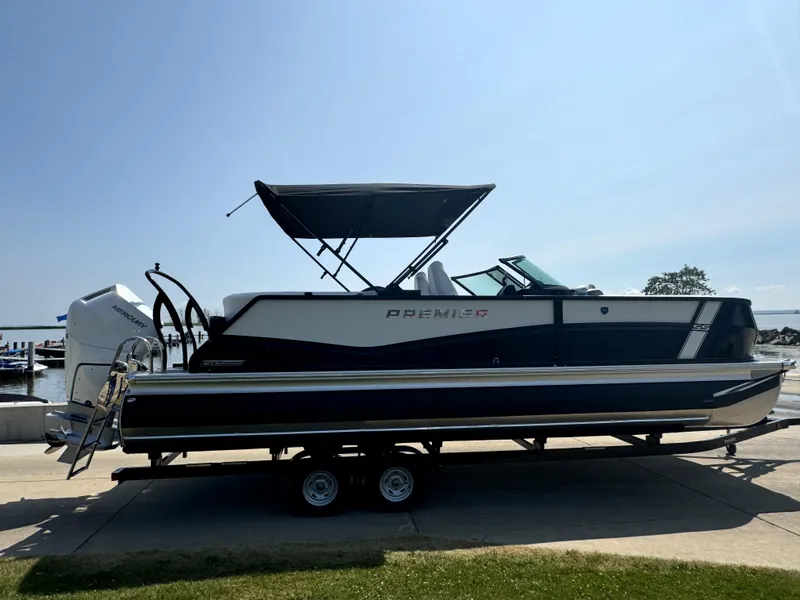 Slide: The Image of 2024 Premier Supersport boat on trailer, featuring sleek design and canopy, parked near water. - 5