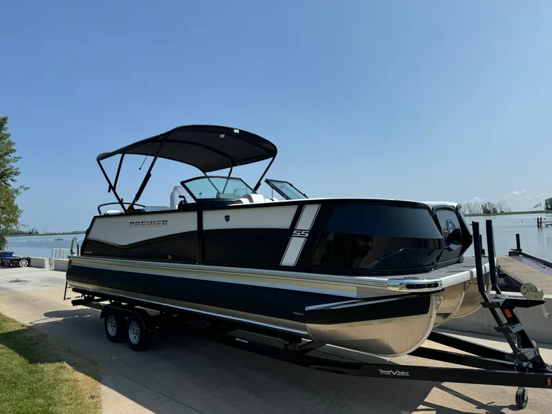 Slide: The Image of 2024 Premier Supersport boat on trailer by lakeside, under clear blue sky. - 6
