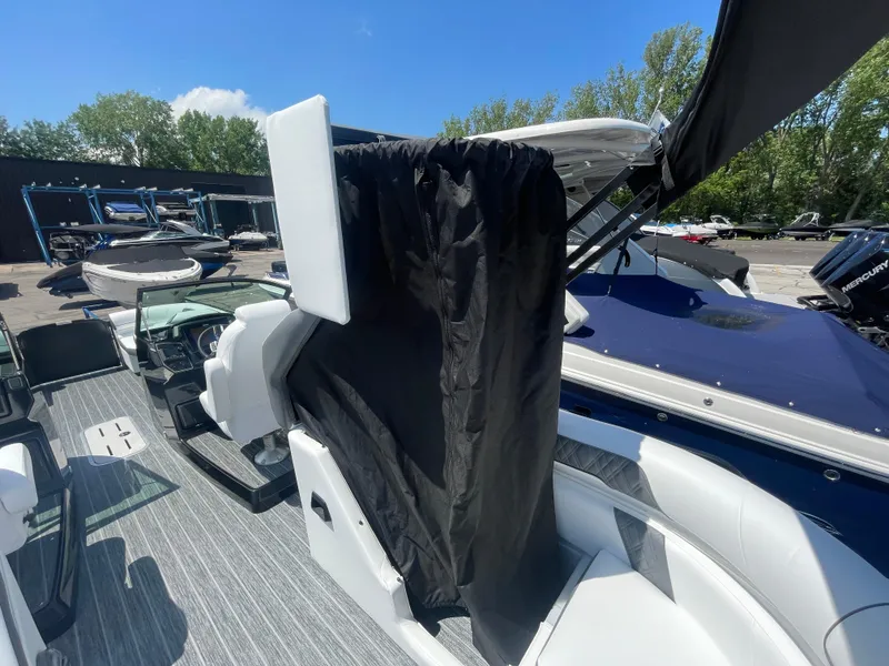 Slide: The Image of 2024 Premier Supersport boat interior with seating and canopy, parked outdoors. - 9