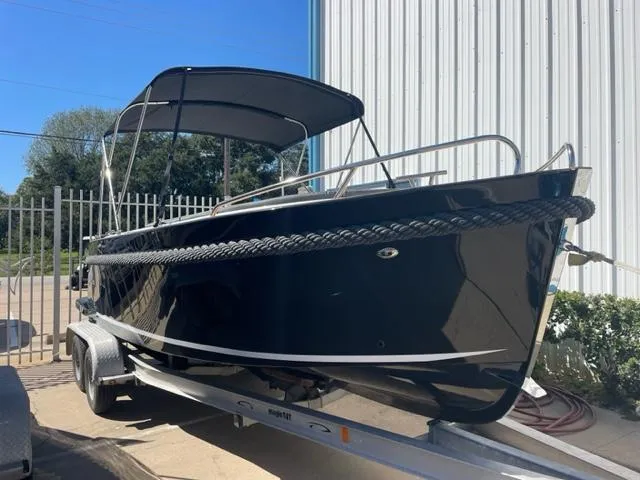 Slide: The Image of 2023 Maxima 620 Retro boat on trailer with canopy, parked outdoors. - 0