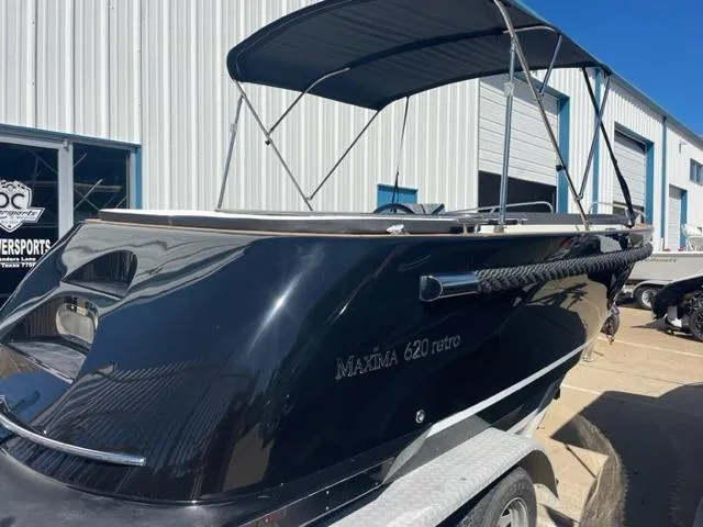 Slide: The Image of 2023 Maxima 620 Retro boat with canopy on trailer outside a warehouse. - 1