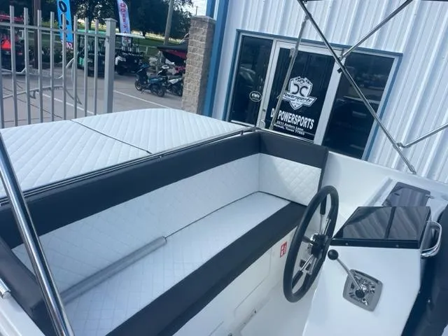 Slide: The Image of 2023 Maxima 620 Retro boat interior with white quilted seating and steering wheel. - 12