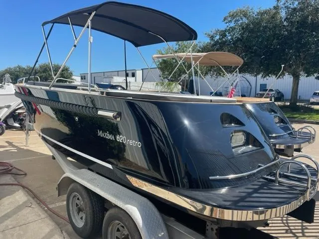 Slide: The Image of 2023 Maxima 620 Retro boat on trailer with canopy, black exterior. - 3