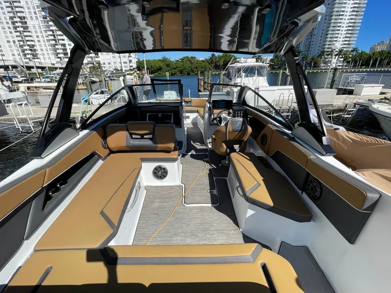 Slide: The Image of Interior of 2020 Scarab 285 ID boat docked at marina, featuring tan and black seating. - 15