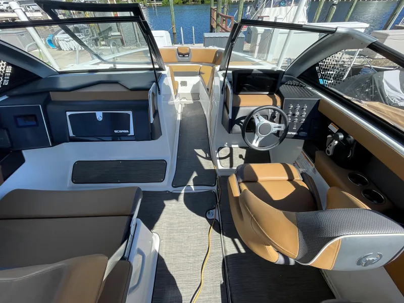 Slide: The Image of 2020 Scarab 285 ID boat interior with brown and white seating, steering wheel, and dashboard. - 16