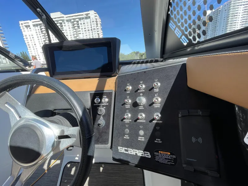 Slide: The Image of 2020 Scarab 285 ID boat dashboard with steering wheel and control panel. - 23