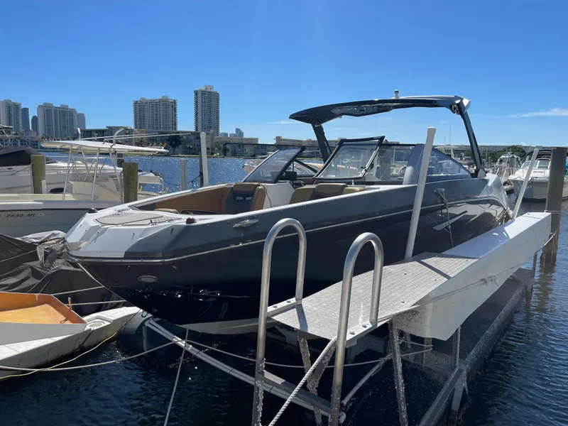 Slide: The Image of 2020 Scarab 285 ID boat docked at marina with city skyline in background. - 3