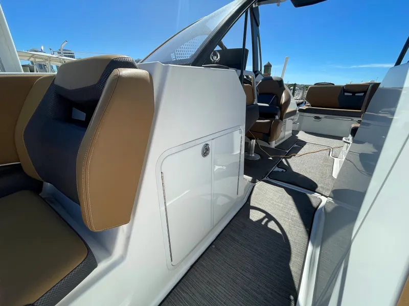 Slide: The Image of 2020 Scarab 285 ID boat interior with brown and black seating, white storage compartment. - 35