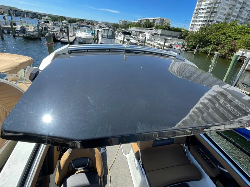 Slide: The Image of 2020 Scarab 285 ID boat docked at a marina with other boats. - 39