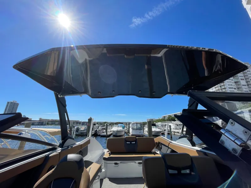 Slide: The Image of 2020 Scarab 285 ID boat interior with sunshade, docked at marina under clear blue sky. - 41
