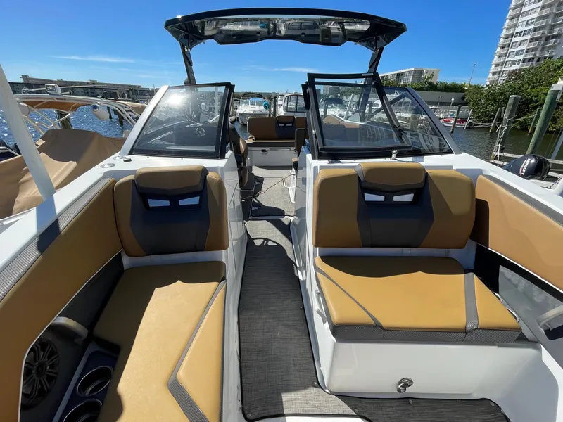 Slide: The Image of 2020 Scarab 285 ID boat interior with tan and black seating, docked at marina. - 6