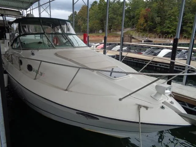 The Image of 1997 Regal 292 Commodore boat docked at marina with forest background. - 0