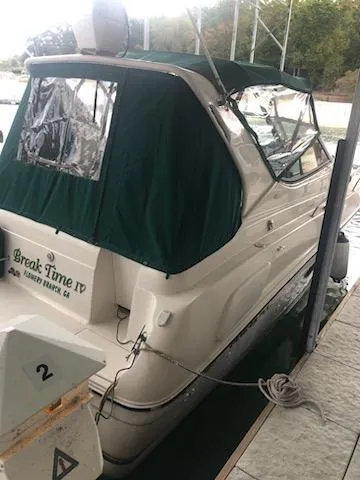 Slide: The Image of 1997 Regal 292 Commodore boat docked with green canopy. - 10