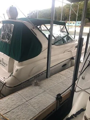 Slide: The Image of 1997 Regal 292 Commodore boat docked with green canopy. - 11