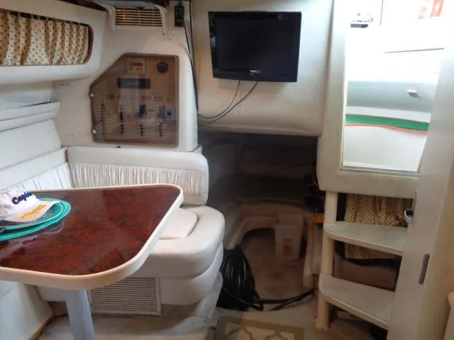 Slide: The Image of 1997 Regal 292 Commodore cabin interior with TV, table, and seating. - 16