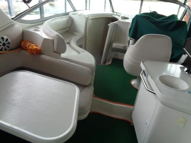 Slide: The Image of Interior of a 1997 Regal 292 Commodore boat with white seating and green carpet. - 2