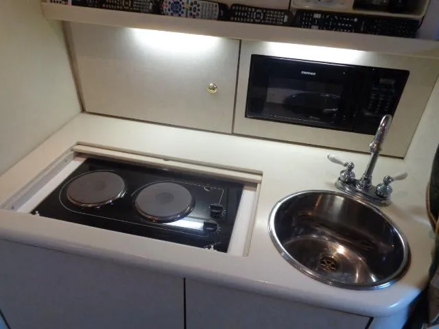 Slide: The Image of 1997 Regal 292 Commodore boat kitchenette with stove, sink, and microwave. - 23