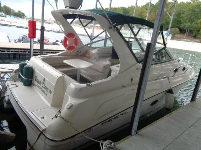 Slide: The Image of 1997 Regal 292 Commodore boat docked at a marina. - 3