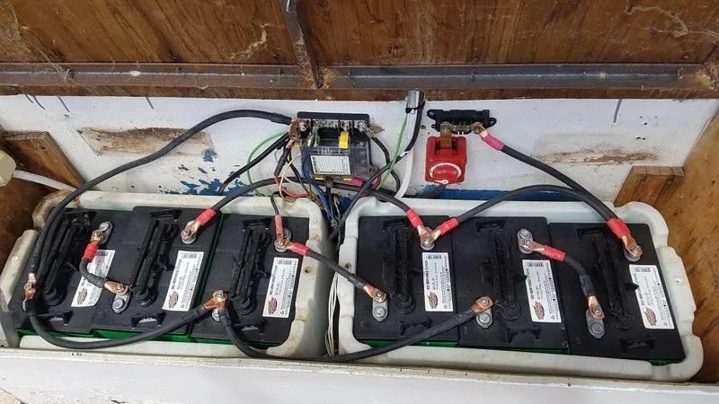 Slide: The Image of 1978 Kayot Houseboat battery compartment with multiple connected batteries and wiring. - 10