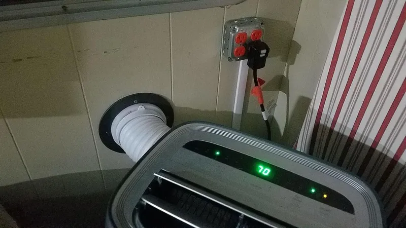 Slide: The Image of Portable air conditioner setup in a 1978 Kayot houseboat, showing vent hose and power outlet. - 12