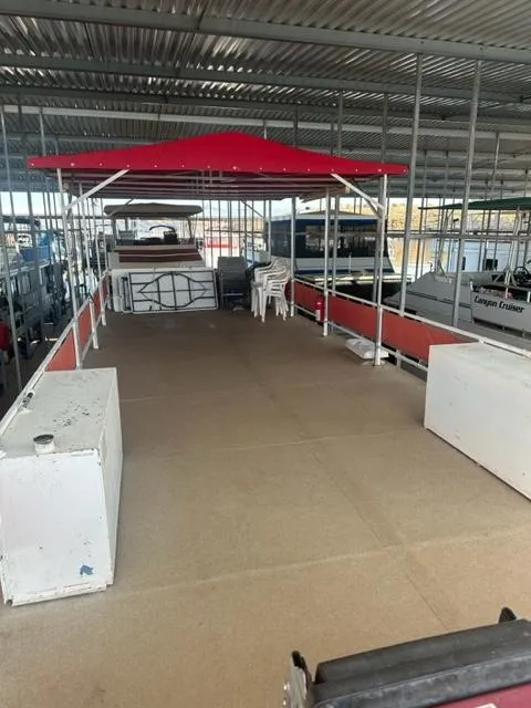 Slide: The Image of 1978 Kayot houseboat with spacious deck and red canopy in a marina. - 17