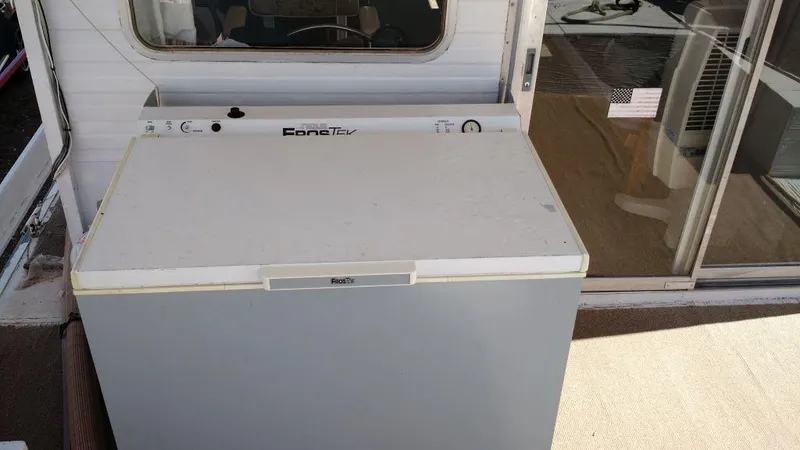 Slide: The Image of 1978 Kayot houseboat with a chest freezer on deck, near sliding glass door. - 27