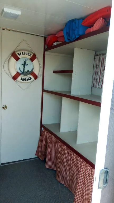 Slide: The Image of 1978 Kayot houseboat interior with shelves, life preserver, and checkered curtain. - 30