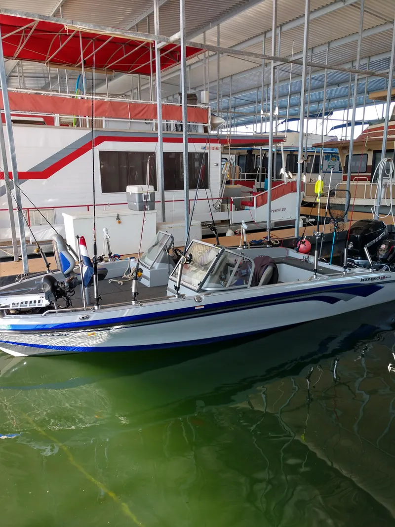 Slide: The Image of 1978 Kayot houseboat docked, with a smaller fishing boat in the foreground. - 37