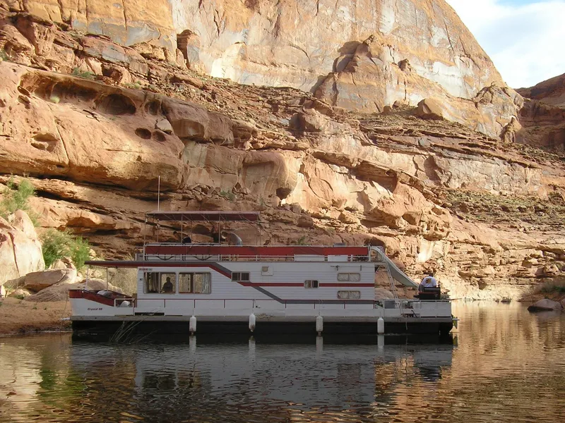 Slide: The Image of 1978 Kayot houseboat on calm water, surrounded by rocky canyon landscape. - 39