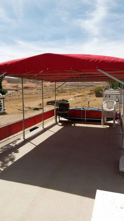 Slide: The Image of 1978 Kayot houseboat deck with red canopy and outdoor seating. - 7