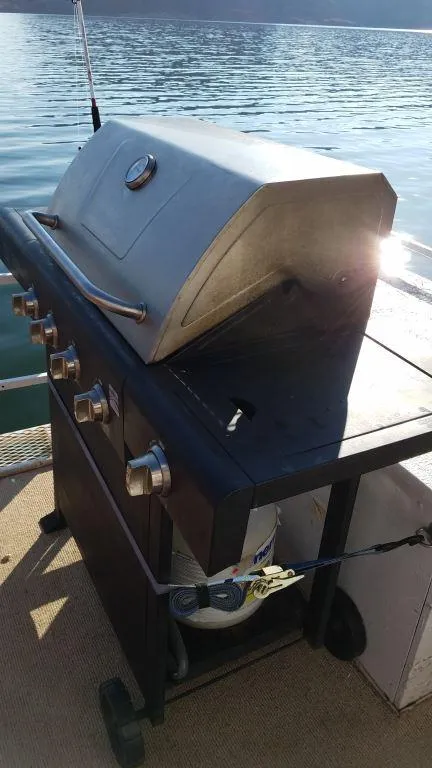 Slide: The Image of Outdoor grill on a 1978 Kayot houseboat deck by the water. - 9