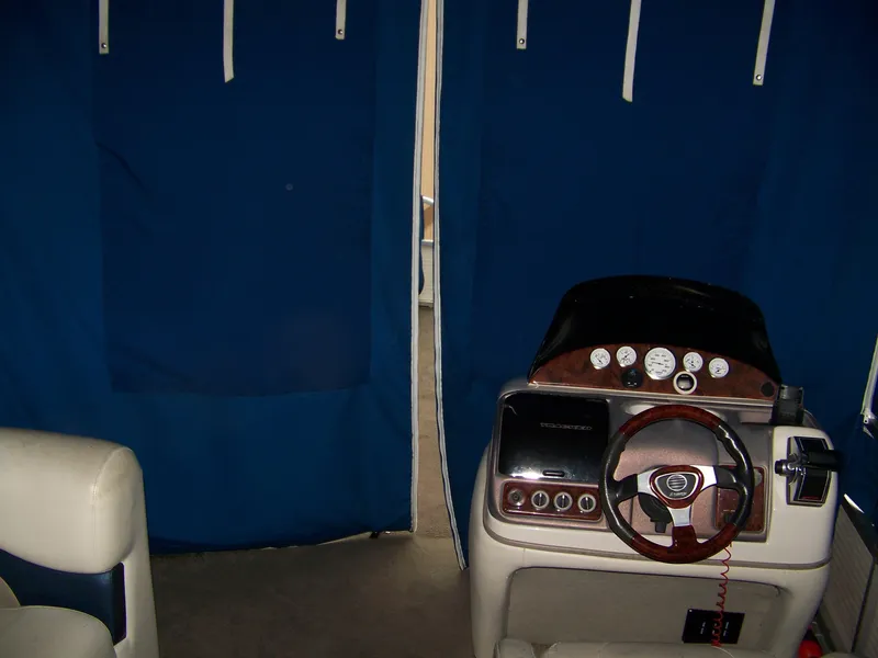 Slide: The Image of Interior of a 2005 Sun Tracker Party Barge 25 boat with blue curtains. - 10