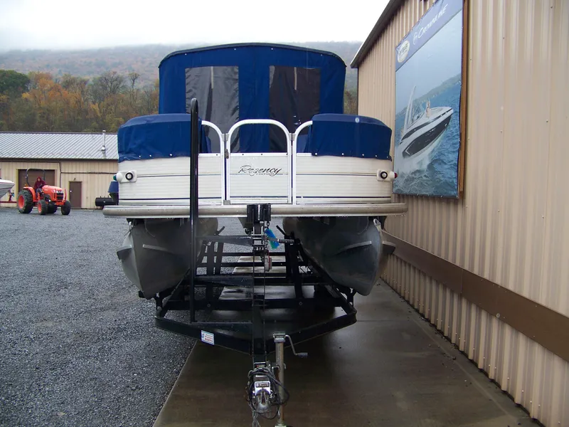 Slide: The Image of 2005 Sun Tracker Party Barge 25 Regency on trailer, parked sideways. - 3