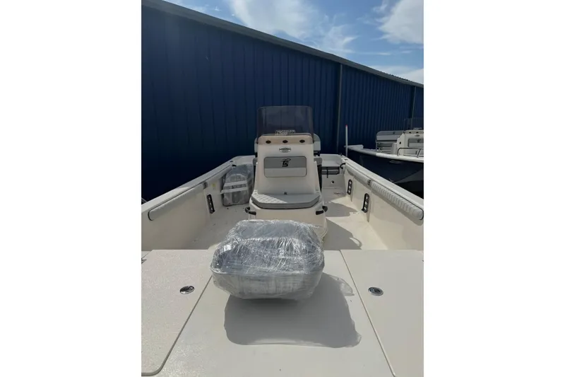 Slide: The Image of 2026 Carolina Skiff 21 LS boat, interior view, wrapped seat, blue building background. - 4