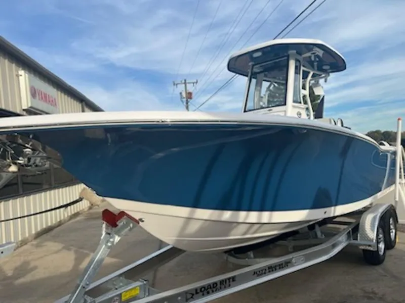 Slide: The Image of 2024 Tidewater 232 LXF boat on trailer, blue hull, parked outdoors. - 1
